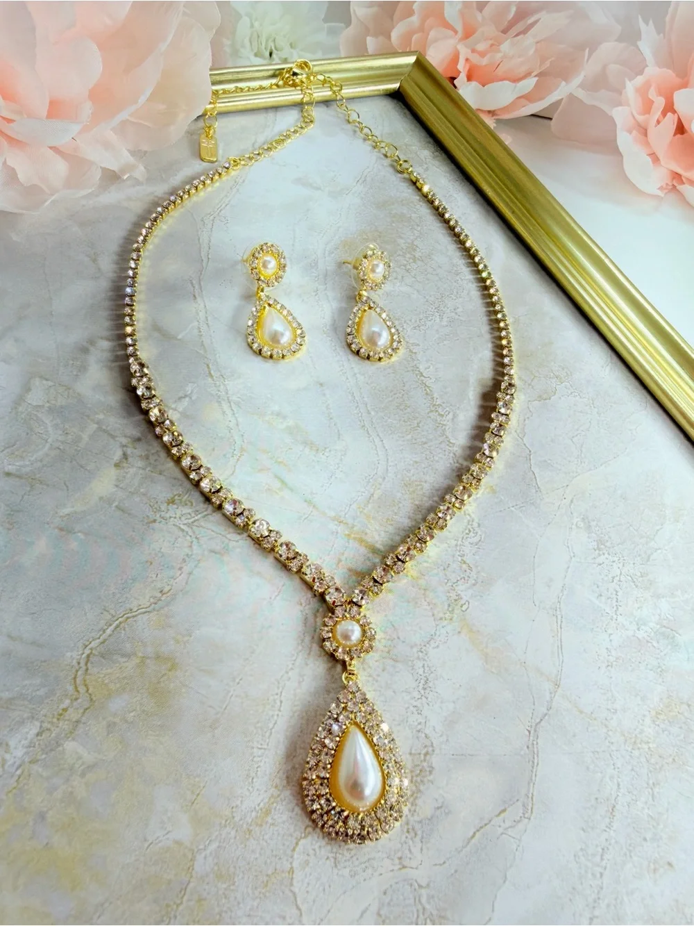 Elegant gold-tone necklace with earrings featuring a white teardrop pearl pendan